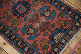 Vintage Lilihan rug's tattered edge, showing indigo floral border, sky blue, and brick red.