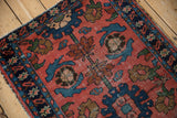 Tattered edge and visible foundation in the worn pile of a vintage Lilihan rug.