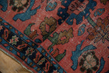 Vintage Lilihan rug's tattered side with floral motifs in dusty red and blue border.