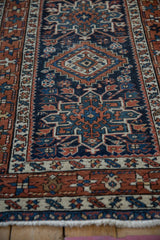 Vintage Karaja rug detail: navy geometric field, chestnut starburst border, ivory highlights, mostly even wear.