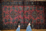 Vintage Lilihan rug featuring large-scale blue and green floral medallions on raspberry red field.