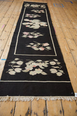 Hand woven black Romanian Kilim runner featuring ivory border and dusty mauve blossoms.
