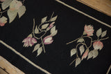 Vintage Romanian Kilim runner's black field with oversized dusty mauve blossoms and leaves.