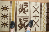 Hand woven Moroccan Kilim rug detail: pictorial animal motif within ivory, coffee brown, and gold bands.