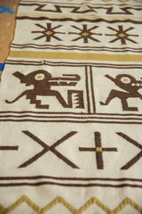 Moroccan Kilim rug showing brown and gold pictorial animal and geometric cross motifs on ivory.