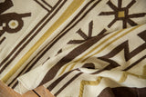 Detail of a vintage Moroccan Kilim runner showing coffee brown and dusty gold pictorial geometric patterns.