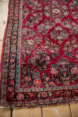 Vintage American Sarouk runner: cherry red field, dense floral spray motifs, and detailed borders.