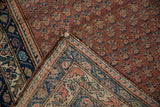 Vintage Hamadan rug corner showing dusty red boteh pile, secure side, and hand-knotted foundation.