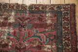 Vintage Mehreban rug corner, tattered with exposed foundation, worn dusty plum and teal patterns.