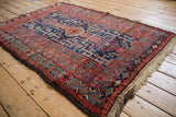 Vintage Kurd rug with brick red geometric border, navy blue field, and mostly intact selvage.