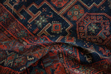 Vintage Kurd rug's textured pile with geometric stepped medallions in navy and brick red.