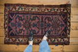 Vintage Mehreban rug corner with worn pale violet field, serpent motif border, tattered fringe.