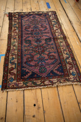 Vintage Mehreban rug corner, showing violet field, serpent motif border, and tattered fringe.