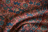 Vintage Lilihan rug showing a textured pile with raspberry, indigo, and green blossom lattice design.