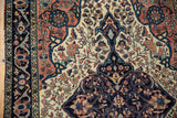Fine antique Farahan Sarouk detail: intricate floral vinery on ivory and navy field.