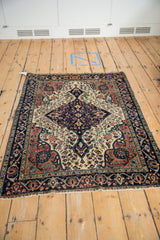 Antique Farahan Sarouk rug's navy border with colorful palmettes and ivory floral field.