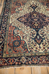 Antique Farahan Sarouk rug end showcasing main border with navy, blush palmettes.