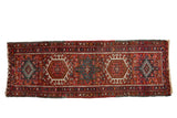 Vintage Persian Karaja runner with geometric hook-and-latch medallions in cherry red and navy blue.