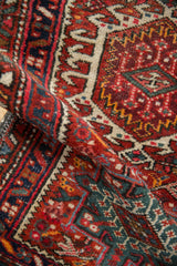 Vintage Karaja runner pile showcasing cherry red and dusty green hook-and-latch motifs.