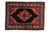 Vintage Persian Malayer rug with a serrated shield-like medallion in brick red and navy blue.