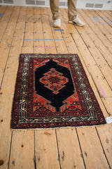 Angled view of the Malayer rug's shield-like medallion and intricate vine border.