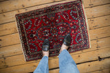 Vintage Lilihan rug's corner with intact cream fringe and floral pattern.