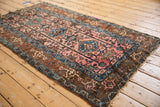 Lilihan rug section with dusty rose field, serrated palmettes, and sapphire blue banded border.