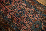 Vintage Lilihan rug's textured pile, showing rose and sapphire serrated palmettes and vines.