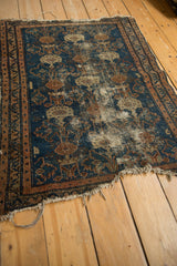Vintage Malayer rug angled view: deep sky blue field, coffee brown border, and tattered fringe.