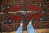 Vintage Malayer rug with cherry red field, diamond medallion, and significant foundation wear.