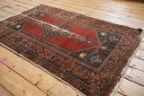 Vintage Malayer rug corner with tattered ivory fringe and blush, red, indigo border.