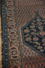 Antique Malayer rug's dusty blush vinery border, reciprocating wave motif, and boteh field.