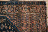 Antique Malayer rug corner: dusty blush boteh field, navy wave, vinery borders, tattered fringe.