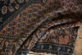 Tattered fringe and outer border of the antique Malayer rug, with navy and dusty blush tones.
