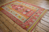 Vintage Turkish Kilim rug showing the geometric prayer design and time-softened red and saffron colors.