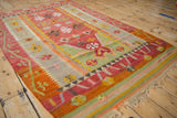 Angled view of a vintage Turkish kilim's flatweave texture and geometric floral motifs.