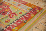 Angled view of the geometric border and colorful flatweave on a vintage Turkish Kilim rug.