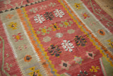 Detailed weave of a vintage Turkish Kilim with geometric florals and a yellow and orange sawtooth border.
