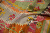 Textured flatweave of a vintage Kilim showing faded saffron, jade, and raspberry red geometric motifs.