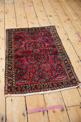 Lilihan rug corner displaying cherry red floral sprays, secure end, and navy, gold, beige border.