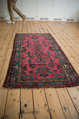 Vintage Mehreban rug corner detail: raspberry red field, geometric sapphire blue border, and fringe.