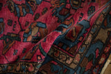 Raspberry red and sapphire blue geometric patterns on vintage Mehreban rug's textured pile.