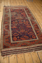 Antique Belouch rug runner's flatwoven end with tatter, openings, and worn fringe; red and navy blue.