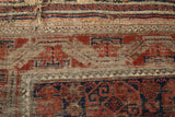 Tattered flatwoven end and worn, exposed foundation on a late 19th-century Belouch rug.