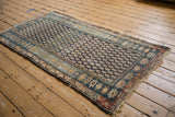 Vintage Hamadan rug corner, indigo field with staggered boteh pattern, multi-hued borders, and worn fringe.