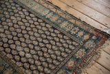 Vintage Hamadan rug end with tattered fringe, madder red, indigo, and ivory boteh pattern.
