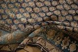 Folded vintage Hamadan rug detail showcasing worn, hand-knotted boteh pattern in blue, ivory, and dusty rose.