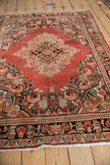 Vintage Arak rug: floral corner spandrel and leaves on a pale cherry red field.