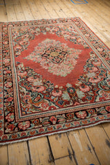 Vintage Arak rug corner with detailed floral borders, cherry red field, and intact selvage.