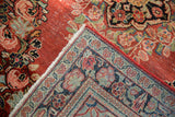 Vintage Arak rug corner revealing red floral pile, back knotting, fringe, and red side cord.